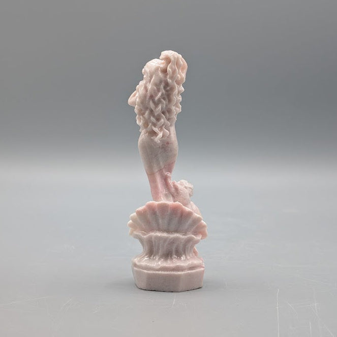 Rear view of a Statute of Aphrodite and cupid a top a claw shell carved from pink opal