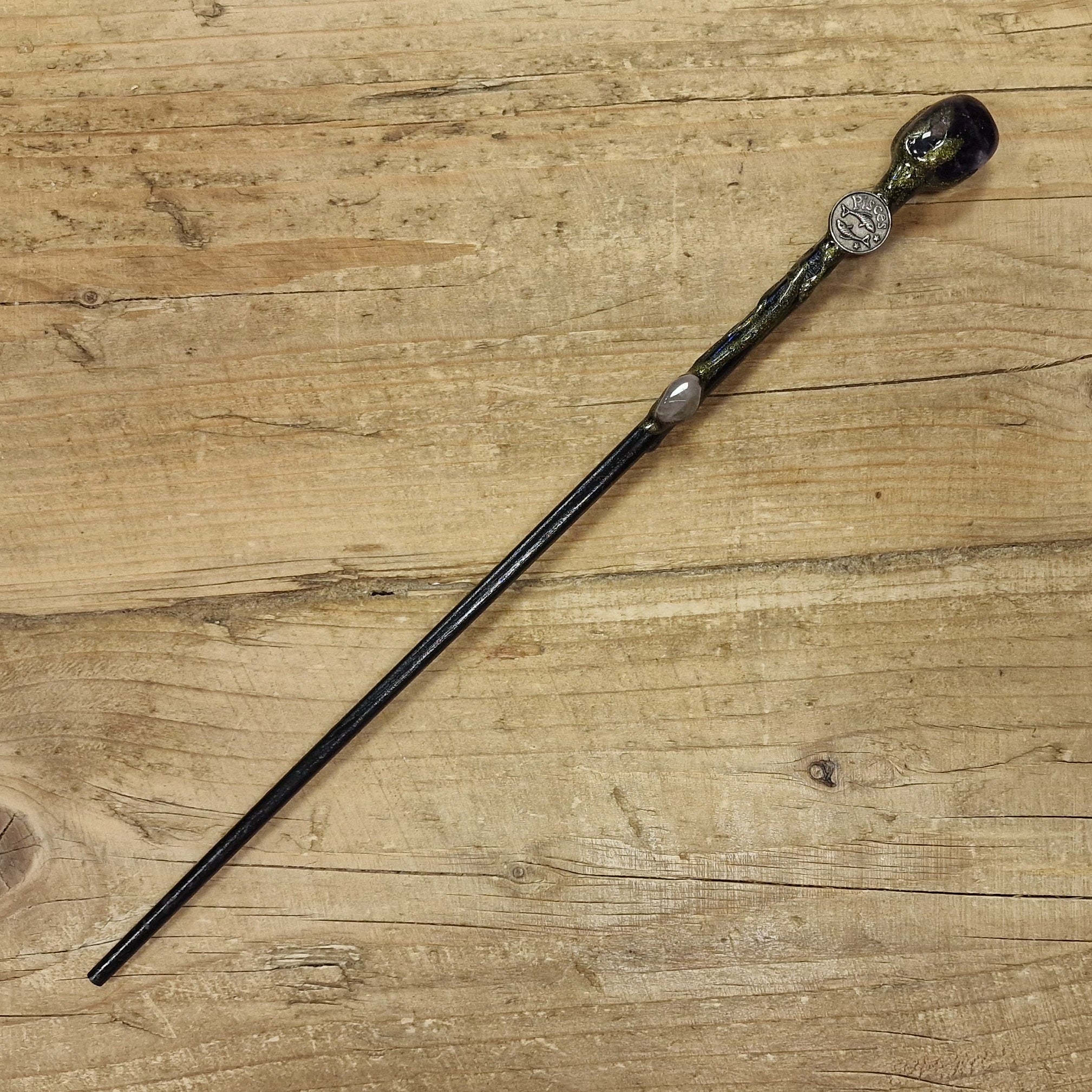 black wooden magic wand with pisces symbol 