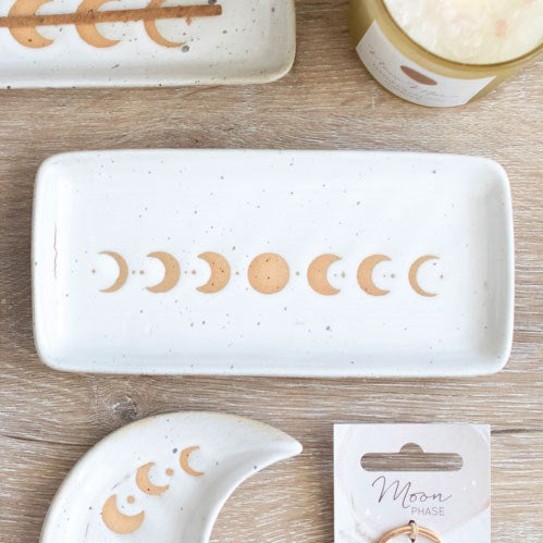 White ceramic dish with moon phases on a wooden background