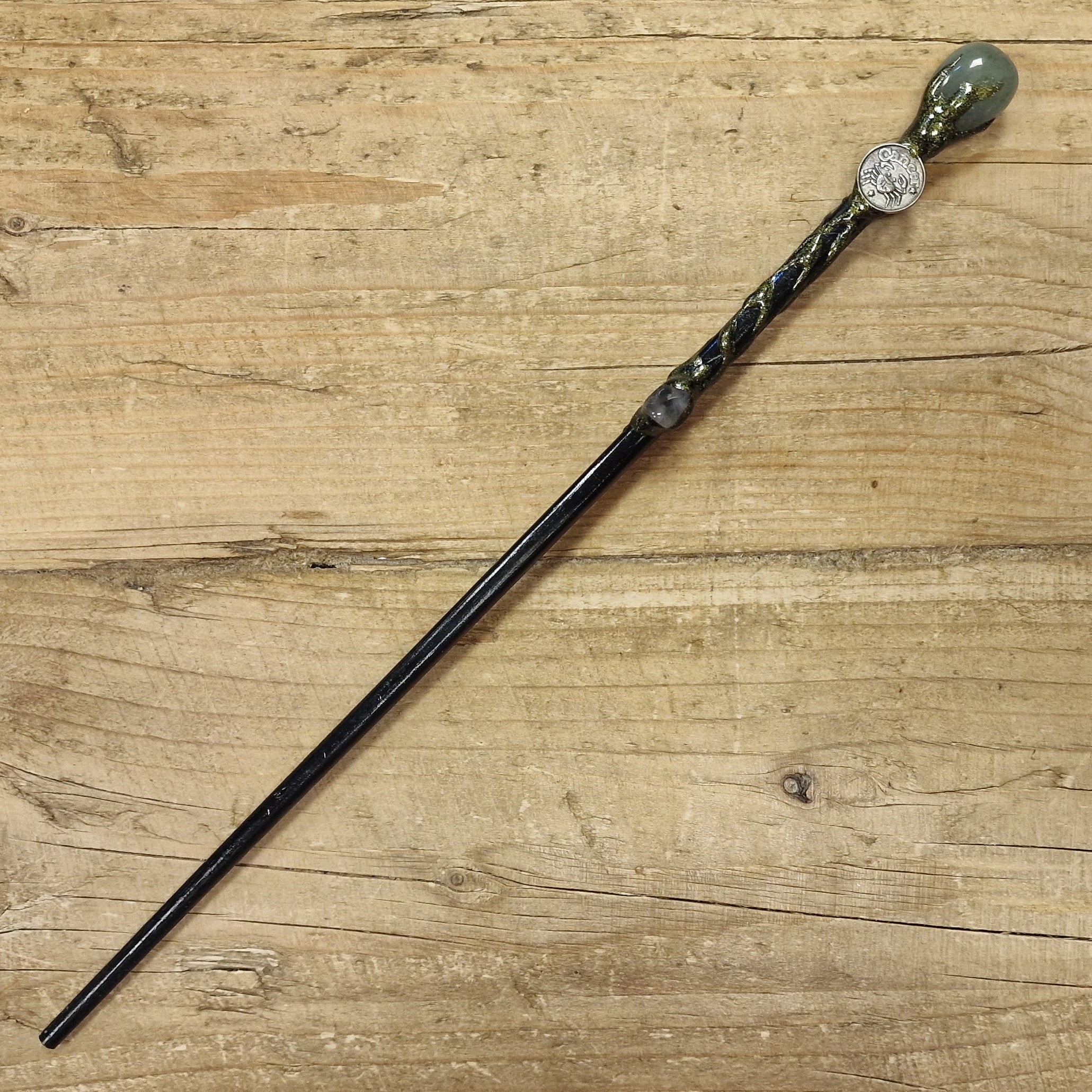 black wooden magic wand with cancer symbol