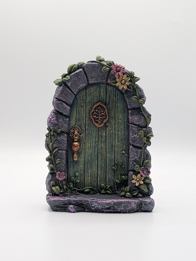 Decorative fairy door with stone arch and floral elements