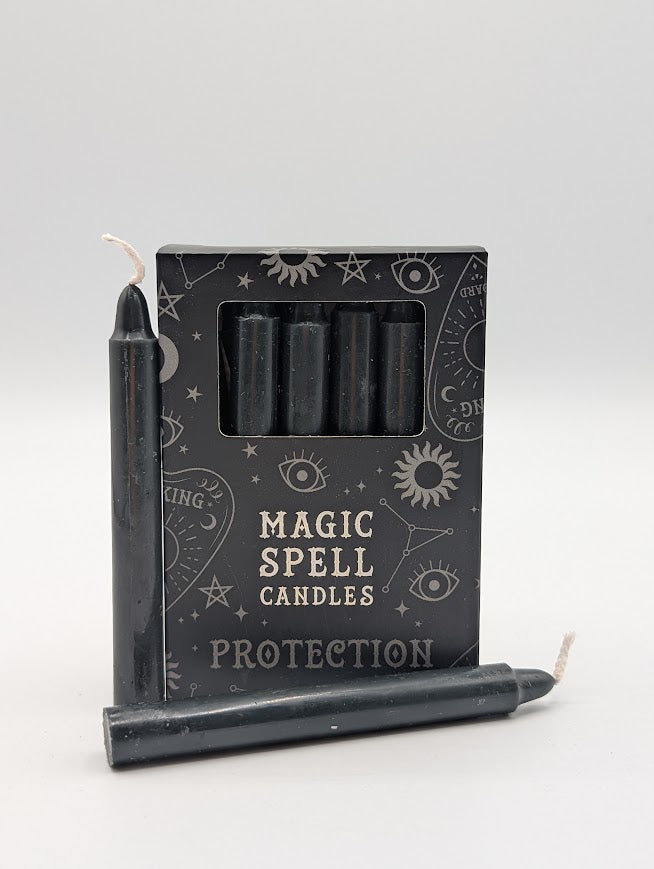 Set of black candles with packaging labeled 'Magic Spell Candles Protection' on a white background