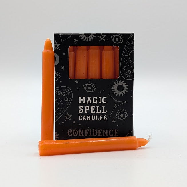 Orange spell candles with packaging labeled 'Magic Spell Candles Confidence' on a white background