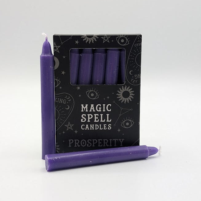 Purple spell candles with a box labeled 'Magic Spell Candles Prosperity' on a white background