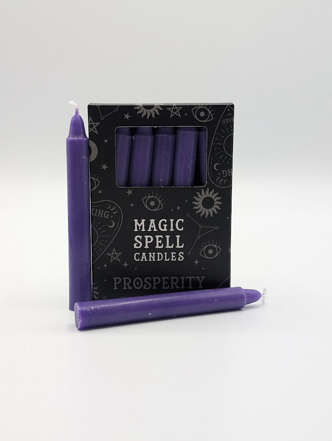 Purple spell candles with a box labeled 'Magic Spell Candles Prosperity' on a white background