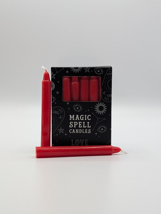 Red spell candles with packaging labeled 'Magic Spell Candles' on a white background