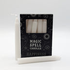 White candles with a black box labeled 'Magic Spell Candles Happiness' on a white background