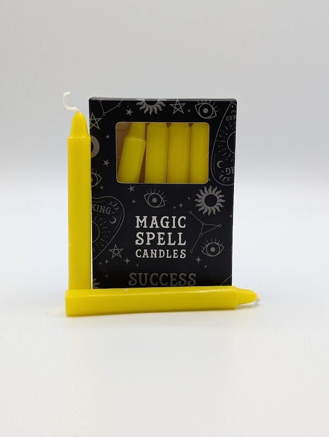 Yellow spell candles with packaging labeled 'Magic Spell Candles Success' on a white background