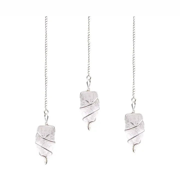 Three clear stone pendulums on silver chains on a white background