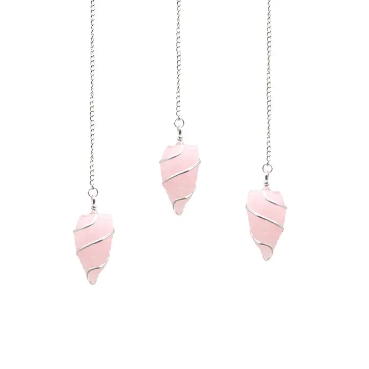 Three pink stone pendulums on silver chains against a white background